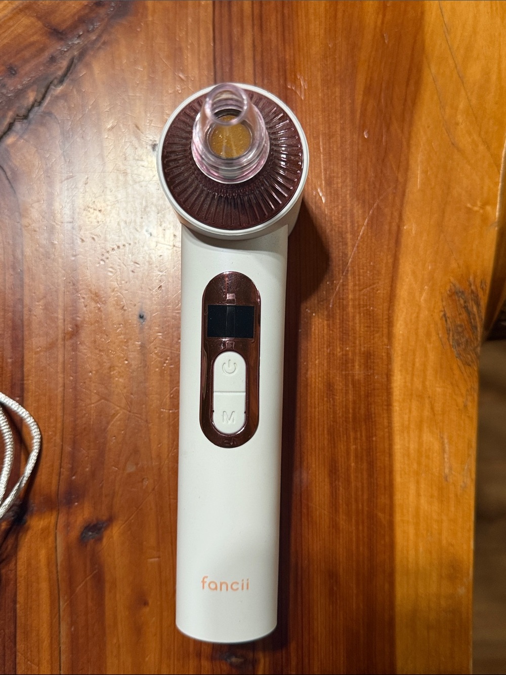 Fancii White & Rose Gold Facial Pore Vacuum and light therapy tool.